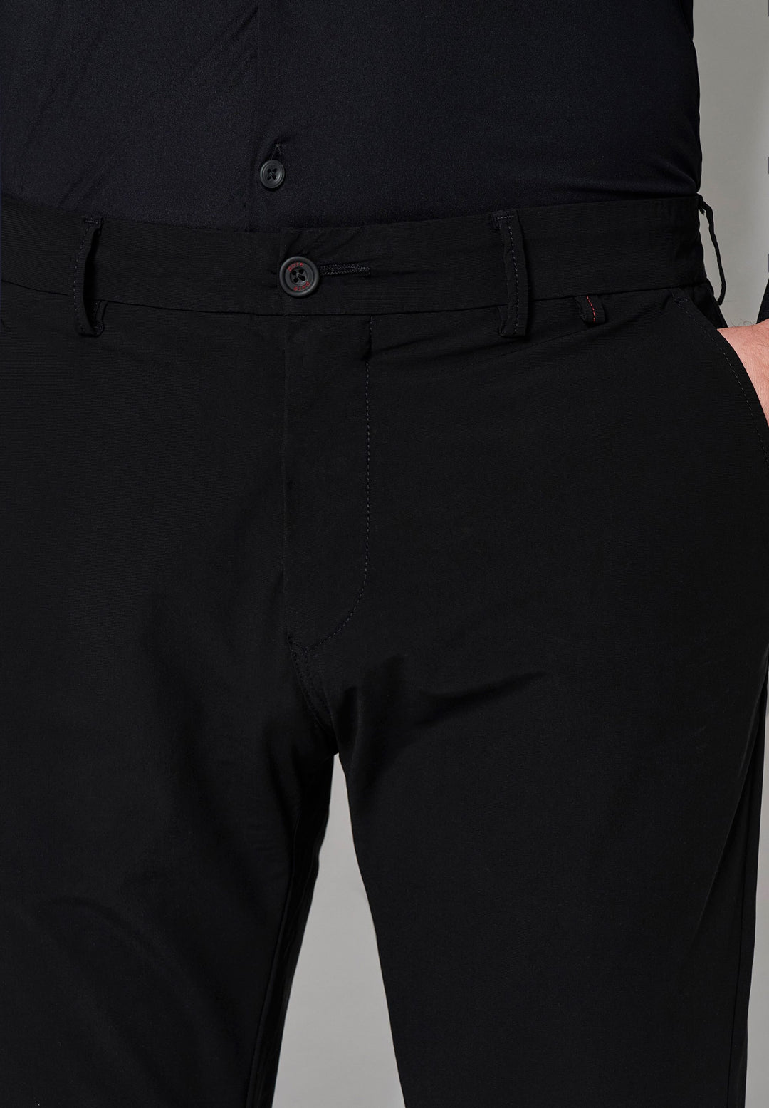 Detailaufnahme der schwarzen Herren Funktionshose mit Knopfverschluss und Gürtelschlaufen. Elastisches Material für optimale Bewegungsfreiheit.