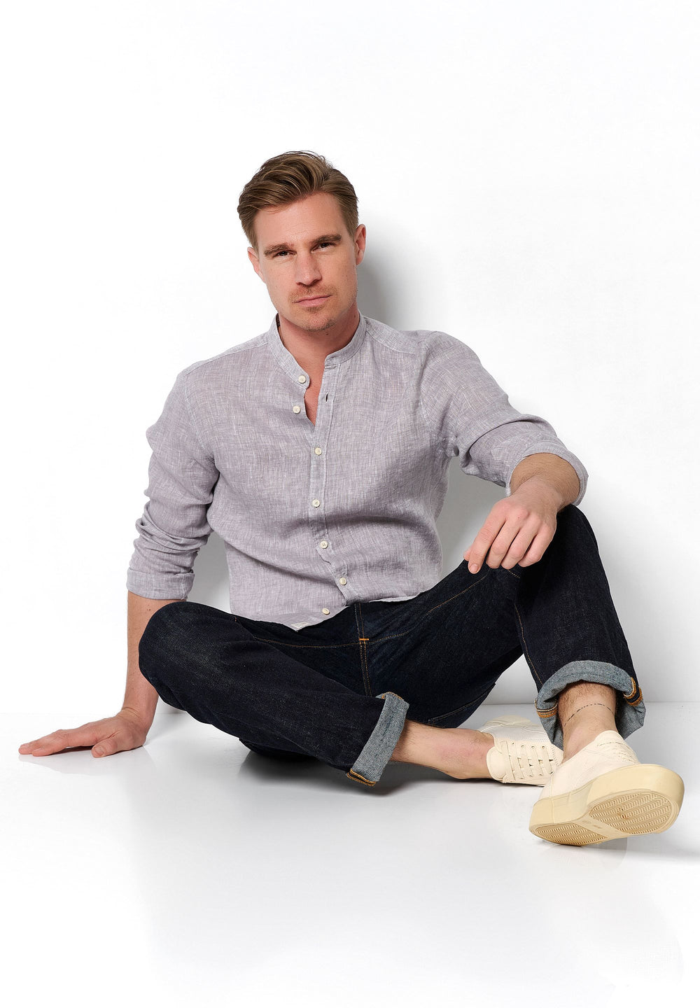 Graues 3805-21620 PURE Casual Herrenhemd aus 100% Leinen mit Stehkragen und Langarm, getragen mit hochgekrempelter dunkler Jeans.
