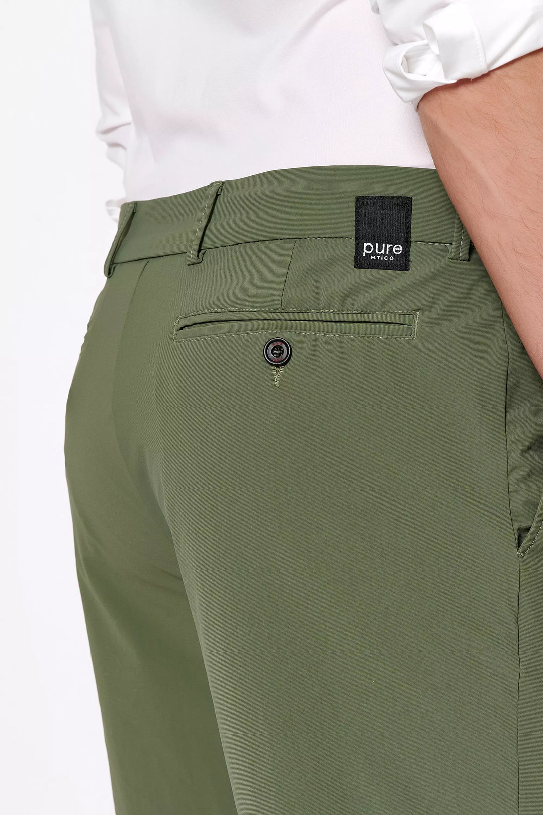 Detailaufnahme der 4798-92975 PURE Functional Bermuda in Grün mit Logo-Patch und Gesäßtasche. Hochwertige Verarbeitung für einen modernen Look.