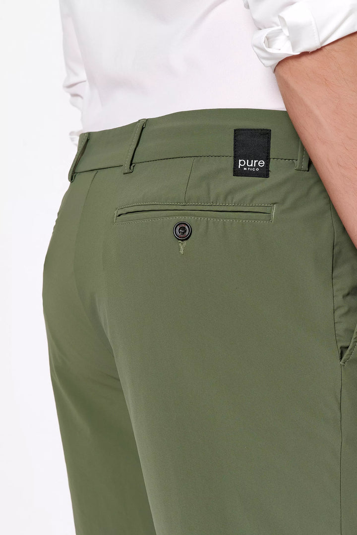 Detailaufnahme der 4798-92975 PURE Functional Bermuda in Grün mit Logo-Patch und Gesäßtasche. Hochwertige Verarbeitung für einen modernen Look.