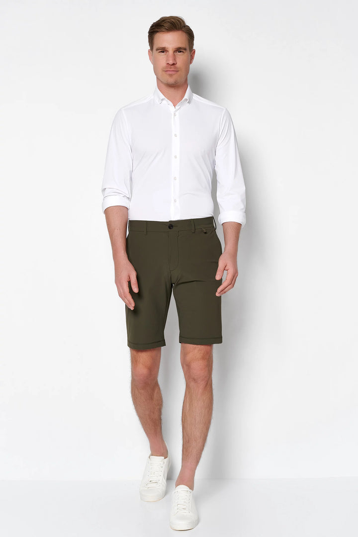 4798-92975 PURE Functional Bermuda in Grün, stilvoll kombiniert mit weißem Hemd und Sneakers. Perfekte Herren-Shorts für einen eleganten Freizeitlook.