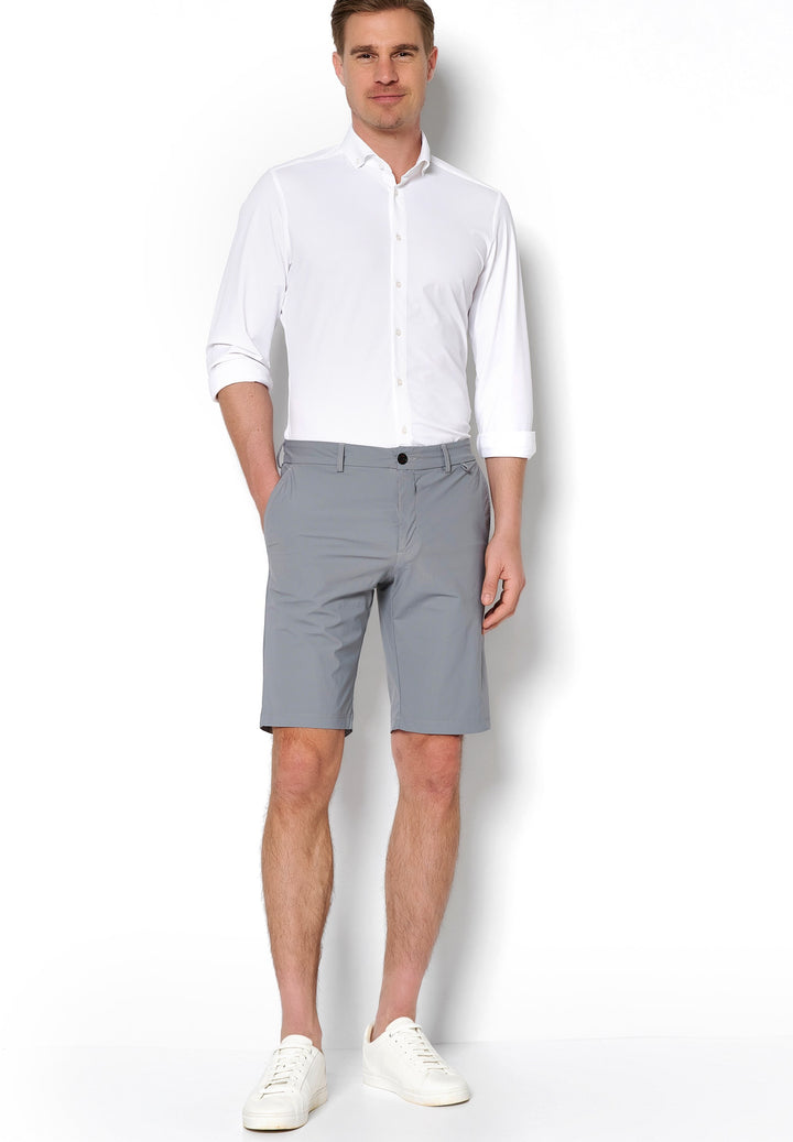 Graue 4798-92975 PURE Functional Bermuda für Herren, kombiniert mit weißem Hemd und Sneakers. Leichte, elastische Shorts für einen stilvollen Look.