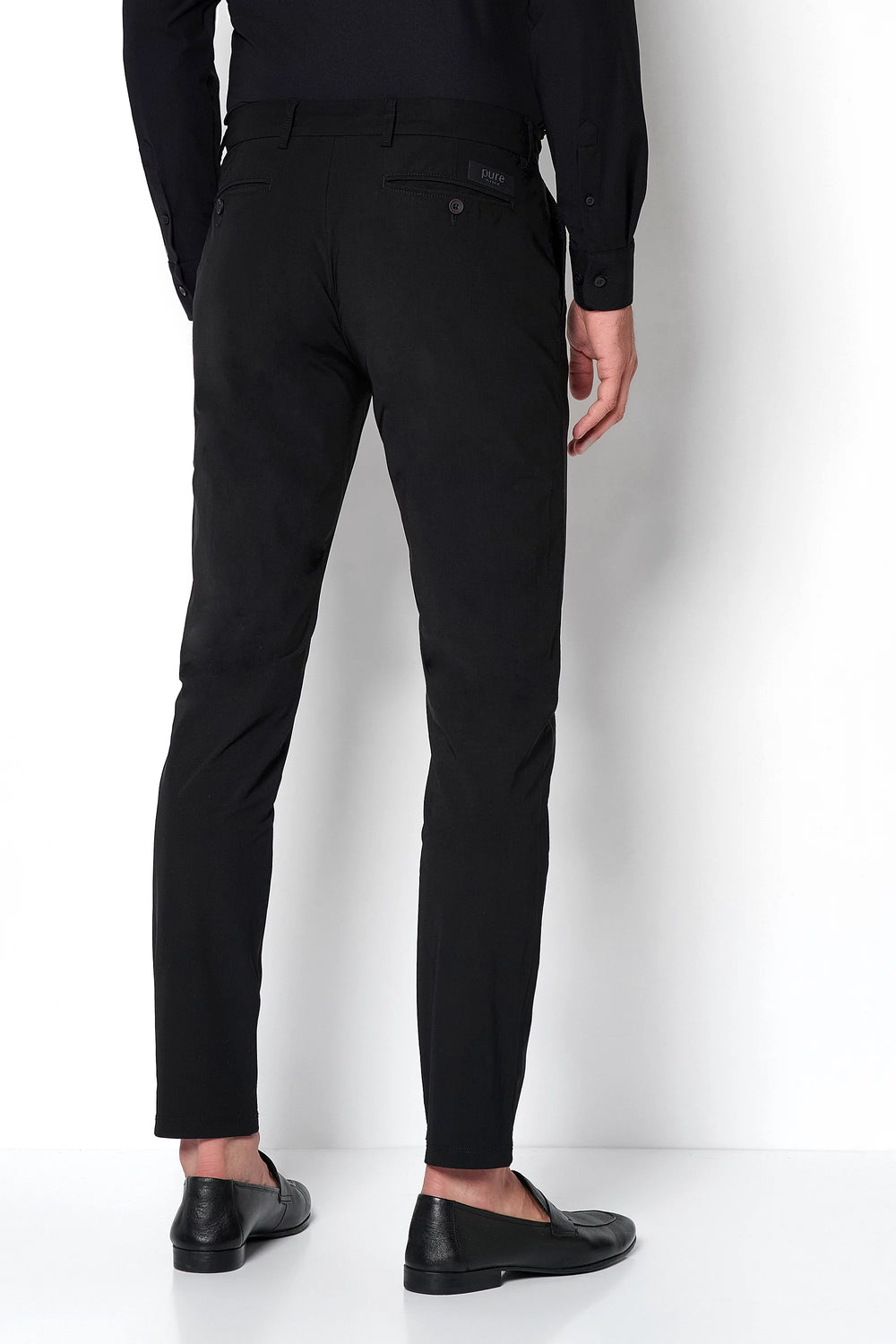 Rückansicht der schwarzen Herren Funktionshose mit schmaler Passform. Perfekt für Komfort und Performance im Alltag oder auf Reisen.