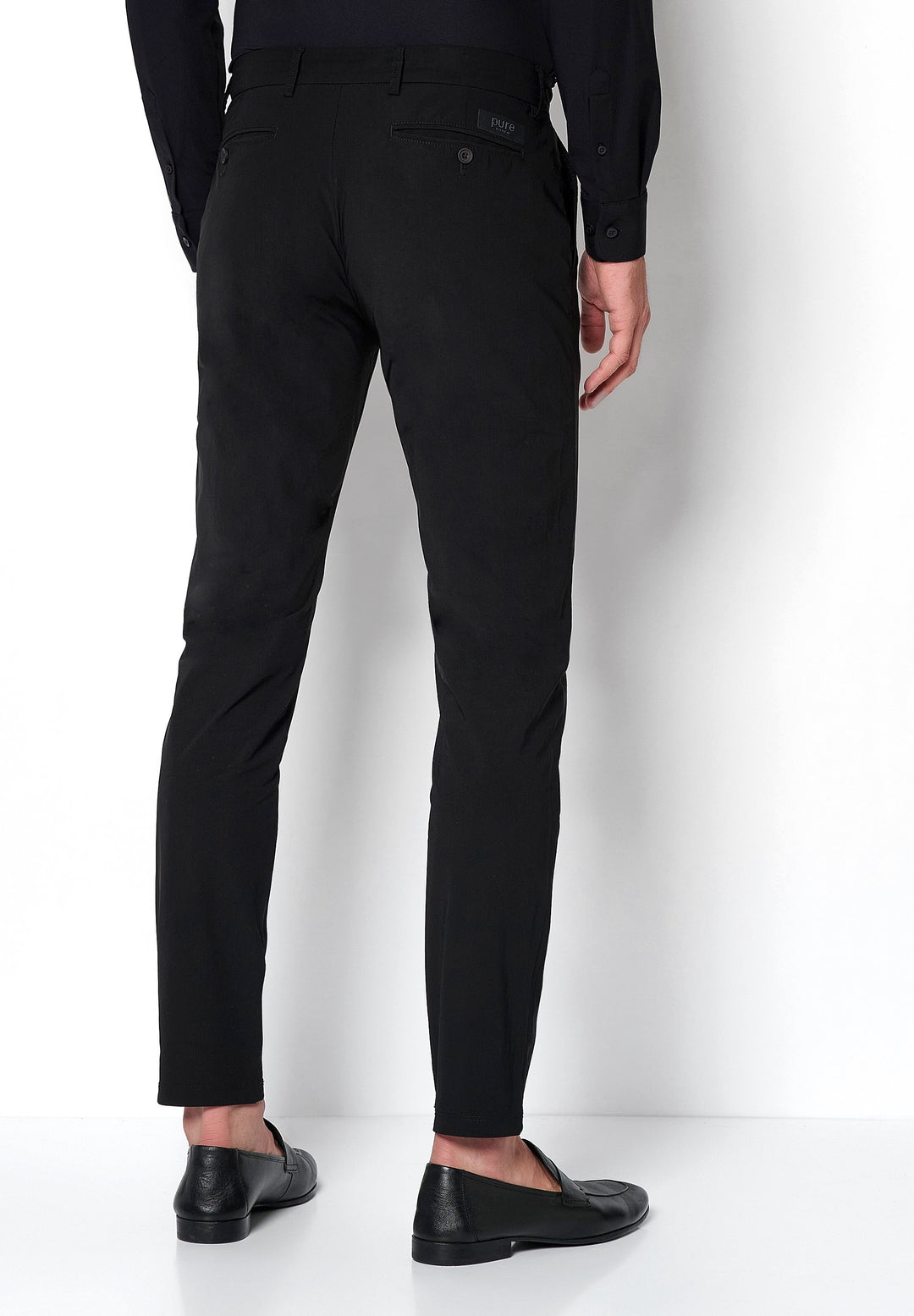 Rückansicht der schwarzen Herren Funktionshose mit schmaler Passform. Perfekt für Komfort und Performance im Alltag oder auf Reisen.