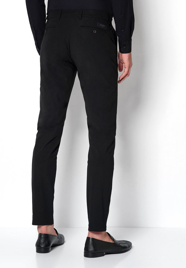 Rückansicht der schwarzen Herren Funktionshose mit schmaler Passform. Perfekt für Komfort und Performance im Alltag oder auf Reisen.