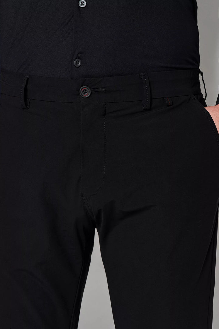 Detailaufnahme der schwarzen Herren Funktionshose mit Knopfverschluss und Gürtelschlaufen. Elastisches Material für optimale Bewegungsfreiheit.